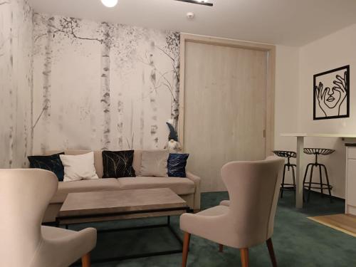 a living room with a couch and two chairs at Grand Apartments Hrebienok in Smokovce