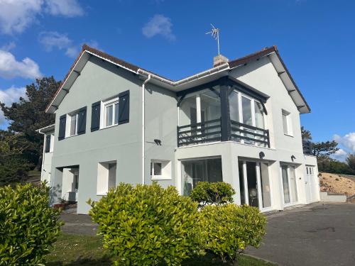 une maison blanche avec un toit noir dans l'établissement Panorama d'EXCEPTION sur Domaine Naturel Protégé et la Mer proche centre La Crête des Dunes Maison complète ou APT uniquement, à Le Touquet-Paris-Plage