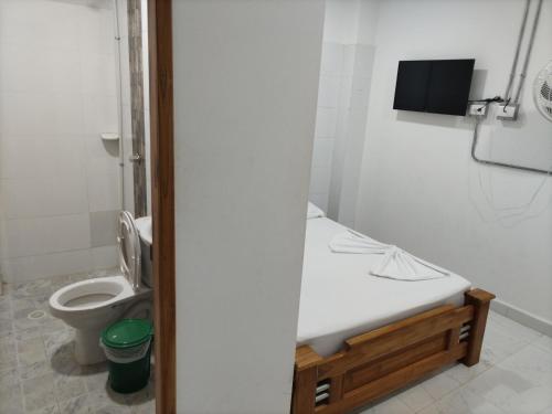 a bathroom with a toilet and a tv on the wall at Playa Mendoza Rest in Necoclí