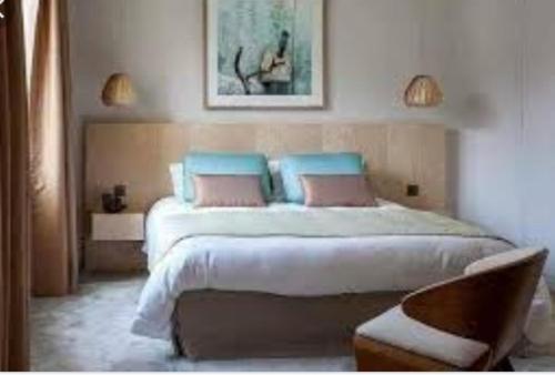 sypialnia z dużym łóżkiem z niebieskimi i różowymi poduszkami w obiekcie إخامن w mieście Chunajfira