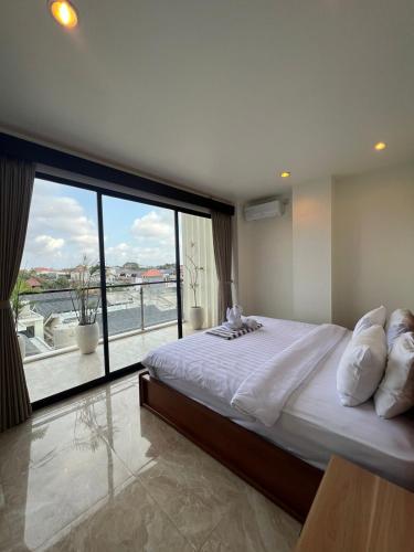 a bedroom with a large bed and a large window at Penthouse Berawa - Canggu in Canggu