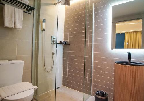a bathroom with a shower and a toilet at Regatta Suites Hotel at Kozi Square Kuching in Kuching