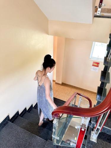 a woman in a dress walking down some stairs at Kim Thành Hotel - 718 Trần Thái Tông, TP Lào Cai - by Bay Luxury in Lao Cai
