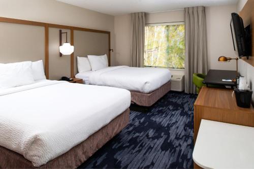 a hotel room with two beds and a window at Fairfield Inn & Suites Greensboro Wendover in Greensboro