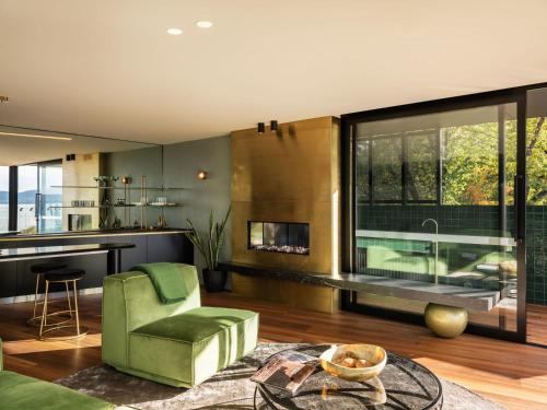 sala de estar con silla verde y chimenea en 'Sydney' - Luxurious waterfront penthouse in Battery Point, en Hobart