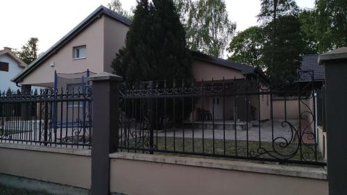 einen schwarzen schmiedeeisernen Zaun vor einem Haus in der Unterkunft Vikendica Nika in Palić