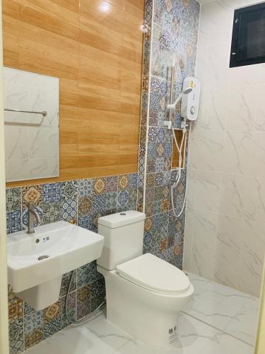 a bathroom with a toilet and a sink at Suanvadee Resort สวนวดี รีสอร์ท in Don Sak