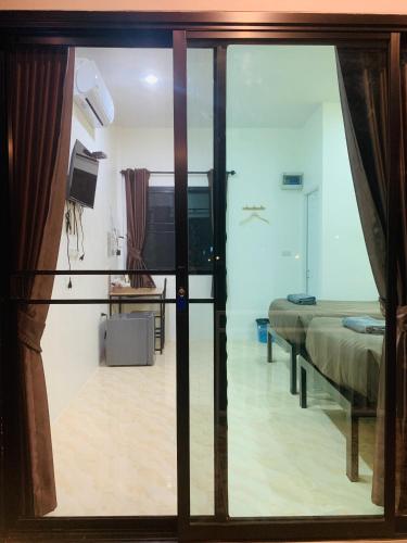 a room with a bed and a sliding glass door at Suanvadee Resort สวนวดี รีสอร์ท in Don Sak