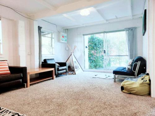 a living room with furniture and a large window at 2 bedroom guest suite in North shore in Auckland