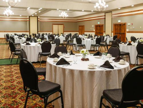 un salón de banquetes con mesas y sillas blancas en Holiday Inn West Yellowstone, an IHG Hotel, en West Yellowstone