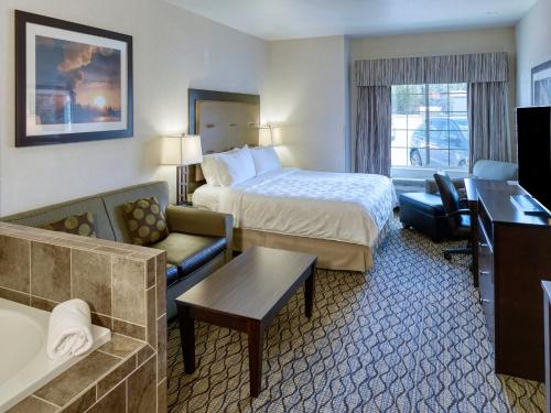 um quarto de hotel com uma cama e uma sala de estar em Holiday Inn West Yellowstone, an IHG Hotel em West Yellowstone