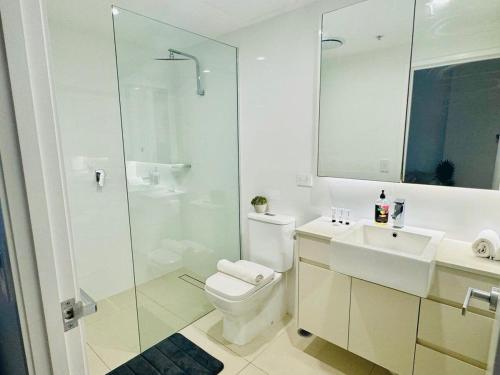 uma casa de banho com um WC, um chuveiro e um lavatório. em CASSA TOOWONG - Convenient 1B Apt at Central Location with Parking Managed by The Cassa em Brisbane