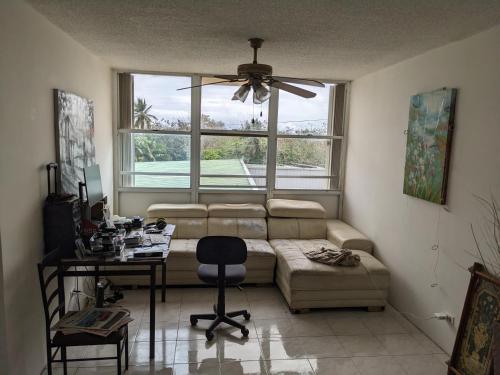 een woonkamer met een bank en een raam bij Private room and bathroom in large spacious 2 BR 2 BH in San Juan