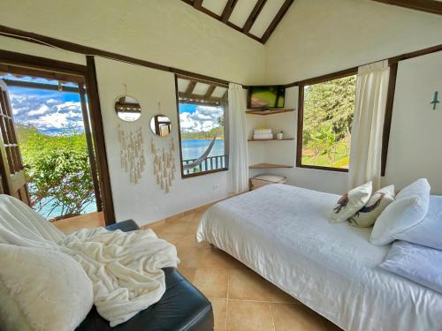 a bedroom with a bed and two windows at El Trebol in Guatapé