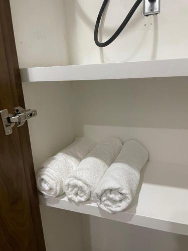 a group of towels sitting on a shelf in a bathroom at Huichol in Mexicali