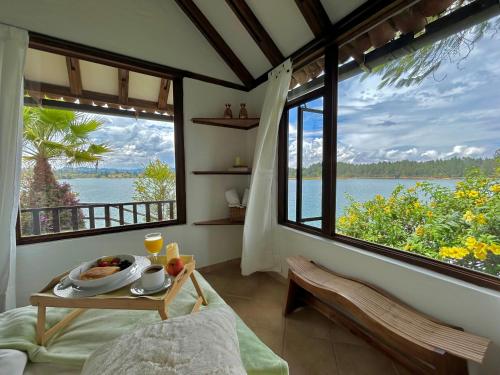 a room with a table with a plate of food and a large window at El Trebol in Guatapé