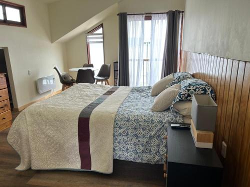 a bedroom with a bed with a blue and white blanket at Eco Nautic Hostel in Valdivia