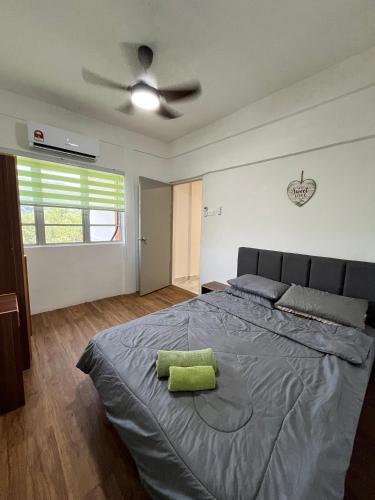 um quarto com uma cama com uma almofada verde em Seruni Apartment em Serendah