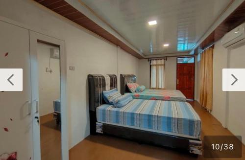 a bedroom with a bed in the middle of a room at Nias Falaga Home in Lagudri