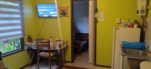 a small kitchen with a table and a refrigerator at Depto interior independiente in Temuco