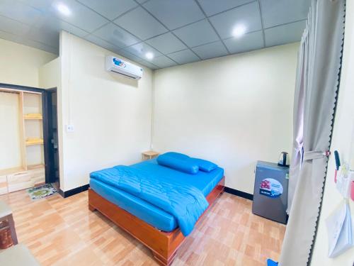 a room with a blue bed in a room at Homestay Bằng Lăng Tím - Bình Thuận in Hàm Tân