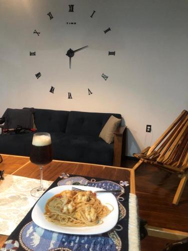 a plate of pasta on a table with a clock on the wall at Loft del mar in Ciudad del Carmen