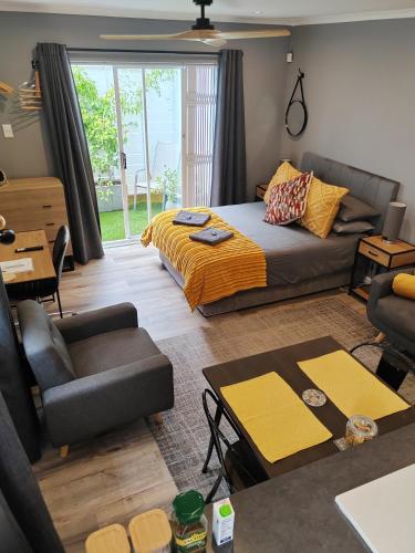 a living room with a bed and a couch at Leafy Retreat Kenridge Trendy in Durbanville