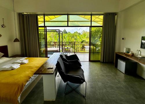 1 dormitorio con cama y vistas a un balcón en 蓝色引力潜水度假村BLUE GRAVITY.WOW DIVING en Panglao City