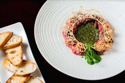 a plate of food with spaghetti and greens on it at Le Méridien Paris Arc De Triomphe in Paris