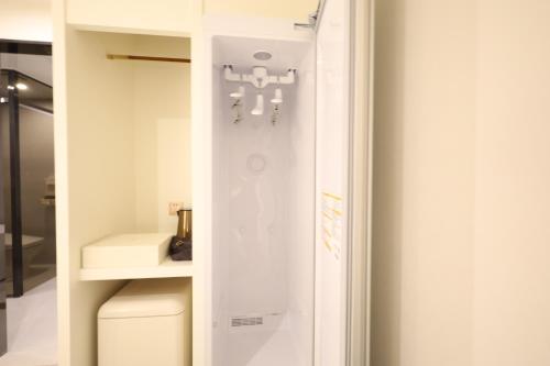a bathroom with a toilet and a chandelier at Changwon Denbasta Hotel Myeongseo in Changwon