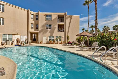 a swimming pool with chairs and a building at La Casita at Surfside 103 in South Padre Island