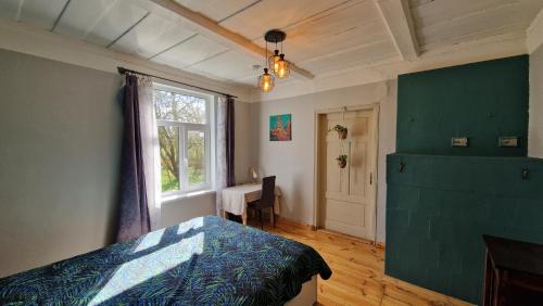 Schlafzimmer mit einem Bett, einem Fenster und einem Schreibtisch in der Unterkunft Ķēniņi 