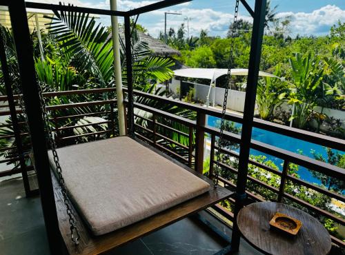 a swing on a balcony with a view of the water at 蓝色引力潜水度假村BLUE GRAVITY.WOW DIVING in Panglao