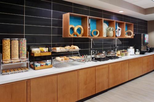 uma linha de buffet com pão e pastelaria em exposição em SpringHill Suites Charlotte University Research Park em Charlotte