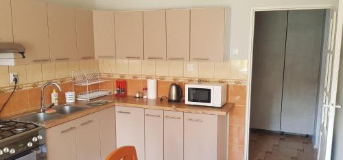 a kitchen with white cabinets and a sink and a microwave at Apartament Pruszcz Gdański 2 in Pruszcz Gdański