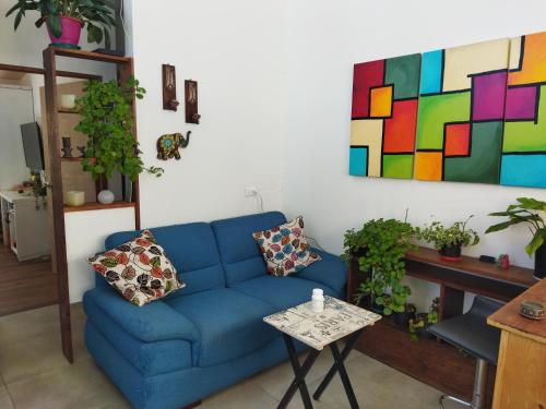 un salon avec un canapé bleu et un tableau dans l'établissement Minicasa solar, à Cajicá