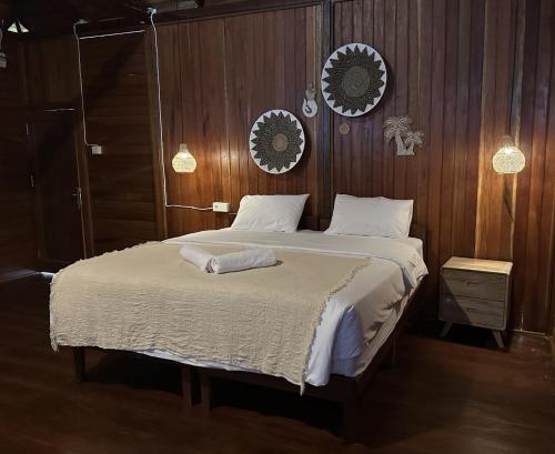 a bedroom with a large bed with wooden walls at Vogelkopf Resort in Tapokreng