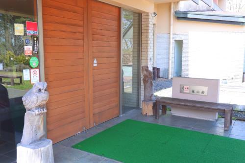 a front door of a house with a dog statue and a bench at hokkein-onsen kougen-terrace in Kokonoe
