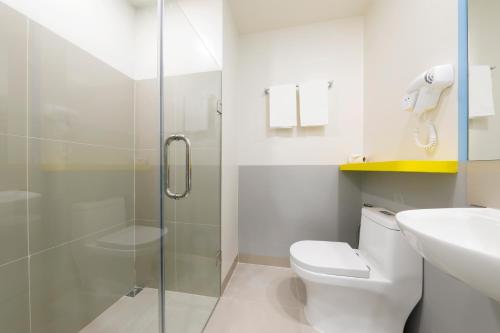 a bathroom with a shower and a toilet and a sink at Hop Inn Hotel Iloilo in Iloilo City