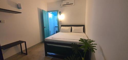 um pequeno quarto com uma cama e uma porta azul em Hello Airport Hotel, Katunayaka em Katunayaka