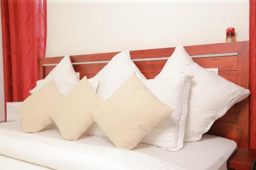 a pile of white pillows sitting on a bed at raison d'être - The Residential Library in Trivandrum