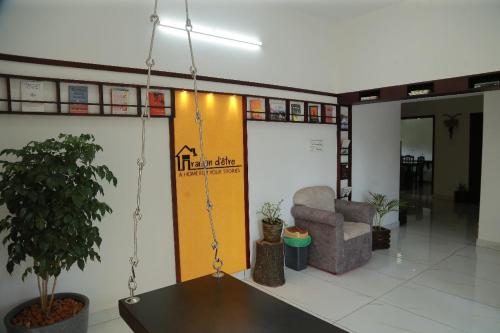 a lobby with a swing in a room with a chair at raison d'être - The Residential Library in Trivandrum