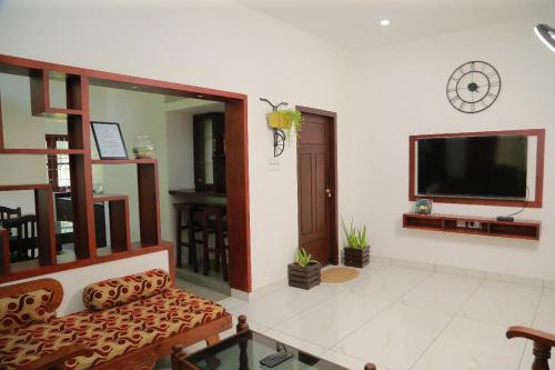 a living room with a couch and a flat screen tv at raison d'être - The Residential Library in Trivandrum