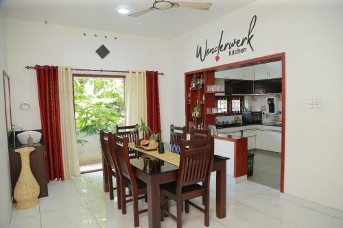 a kitchen and dining room with a table and chairs at raison d'être - The Residential Library in Trivandrum
