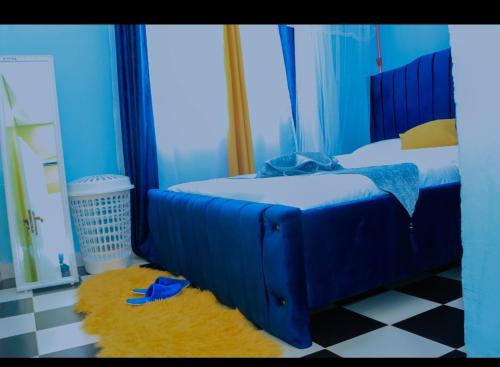 a bedroom with a blue bed and a checkered floor at Greenstar home in Kisii