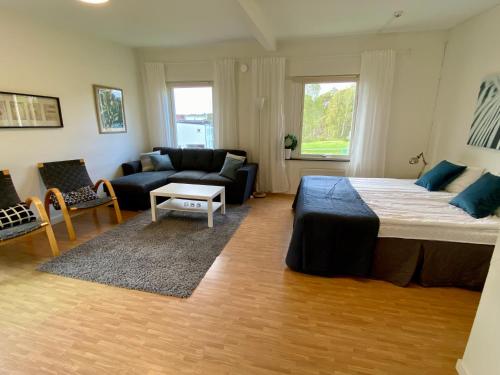 um quarto com uma cama grande e um sofá em Lägenhet i Hällestrand Semesterby, Laxen em Strömstad