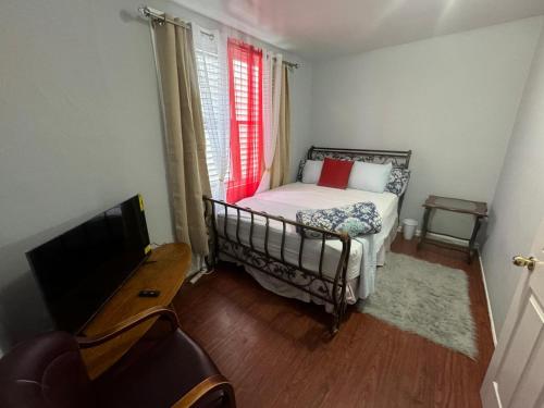 a small bedroom with a bed and a television at Group Getaway of West New York in West New York
