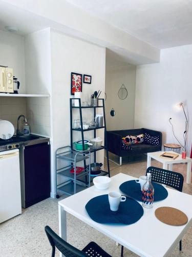 un salon avec une table et des chaises blanches dans l'établissement La MAISON D'ANTONIN, à Nîmes