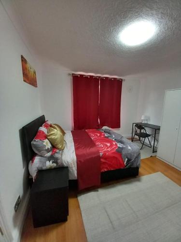 a bedroom with a bed and a red window at JosteeStay Apartments -Rooms in Goodmayes