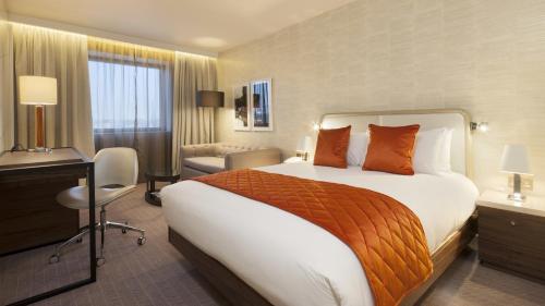 a hotel room with a large bed and a desk at Crowne Plaza London Kings Cross by IHG in London